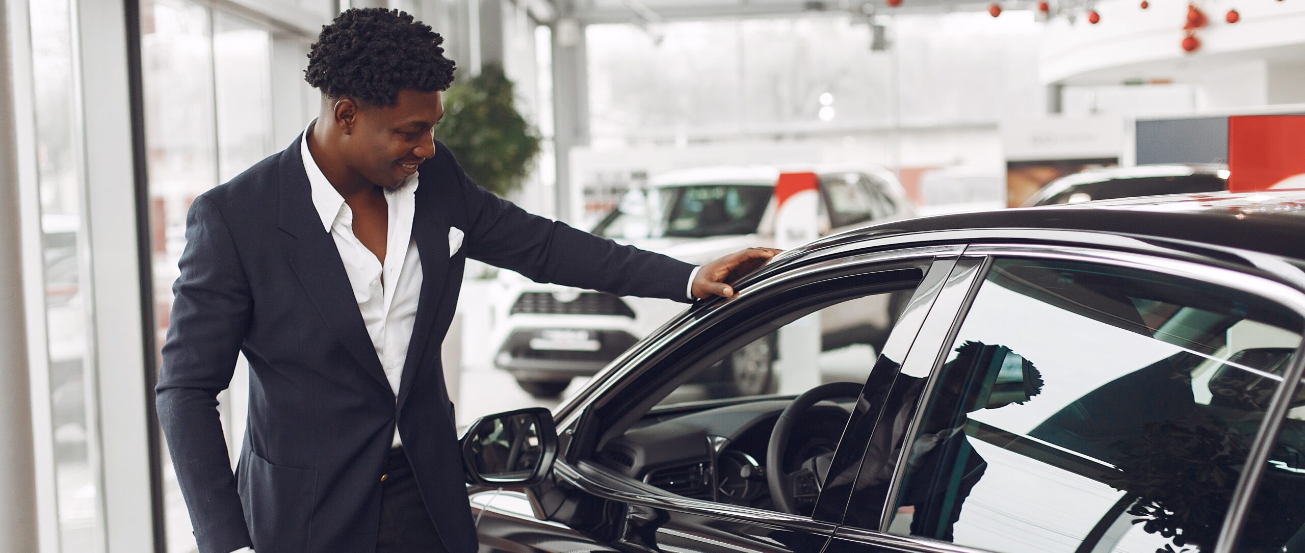 Handsome and elegant black man in a car salon